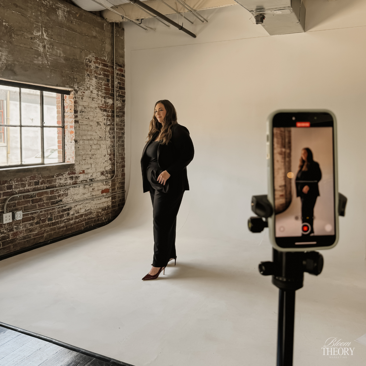 Small business owner filming TikTok video content with phone tripod to grow brand visibility and reach new audiences